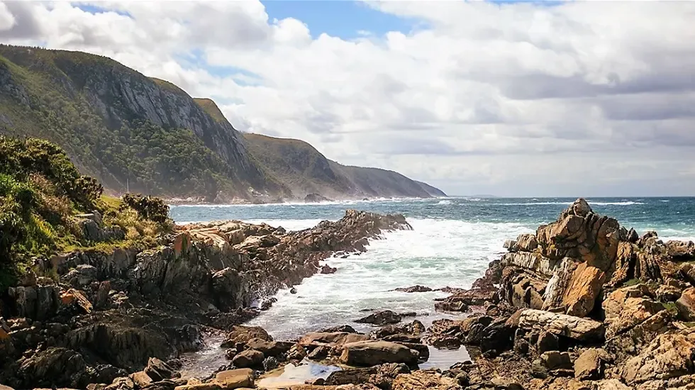 Rocky shoreline and green coastal hills on the route from Tsitsikamma to Addo National Park.