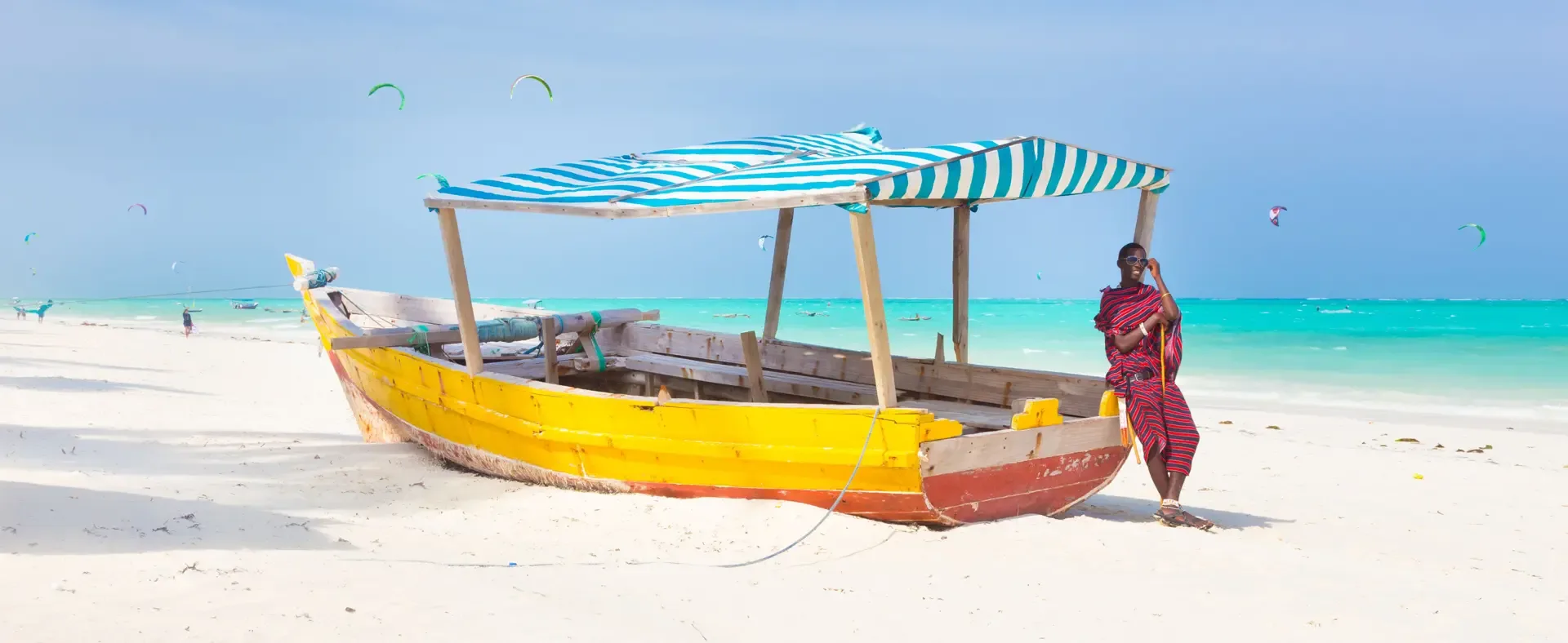 A wooden boat rests on the white sand of Kendwa Beach, Zanzibar.