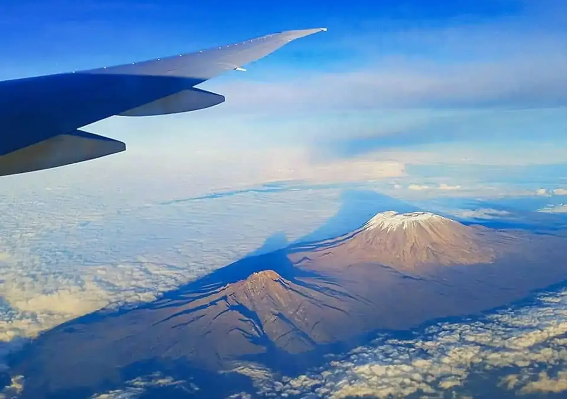 Flying over Kilimanjaro, Tanzania, with the snow-capped summit rising above the clouds.