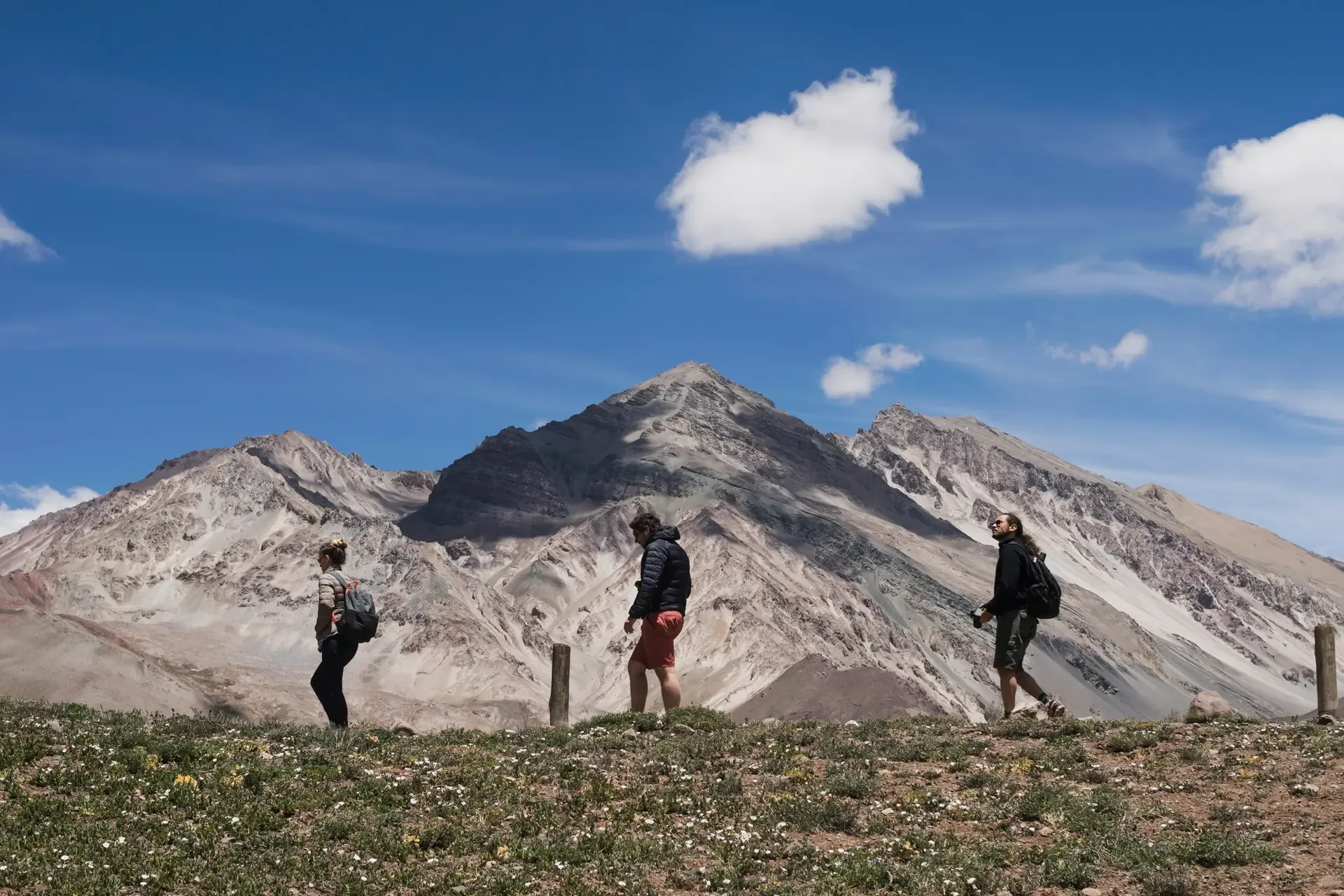 Hikers crossing open ground on Mount Kilimanjaro beneath a clear blue sky.