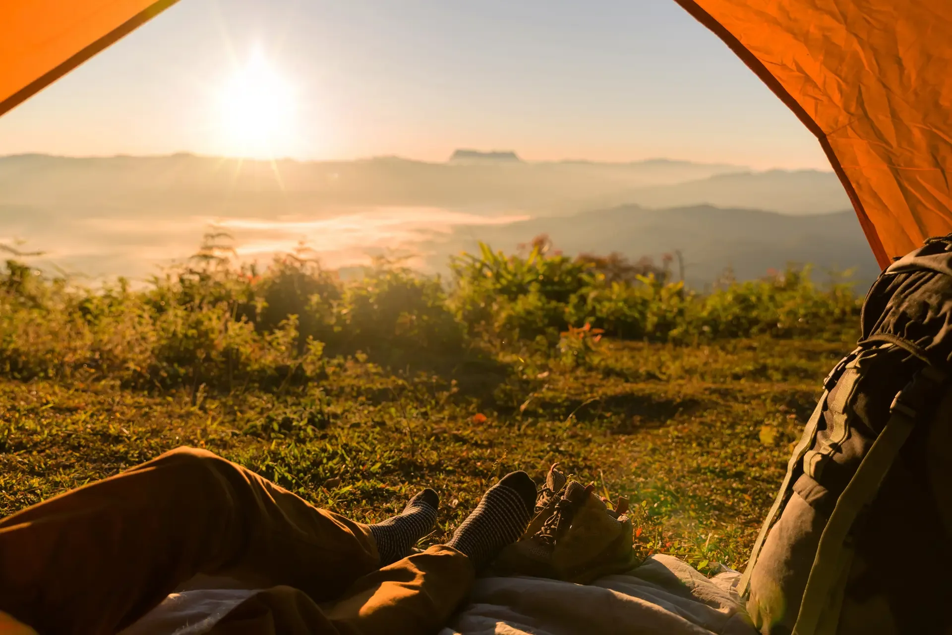 Hiker man sitting tourist tent by travel discovery concept