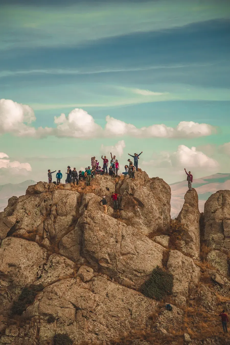 Climbers gather on the rocks at Hikers rock, Tanzania, with arms raised.