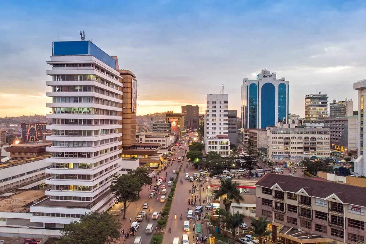 Evening falls over a busy street in Kampala, Uganda, as traffic and pedestrians fill the road.