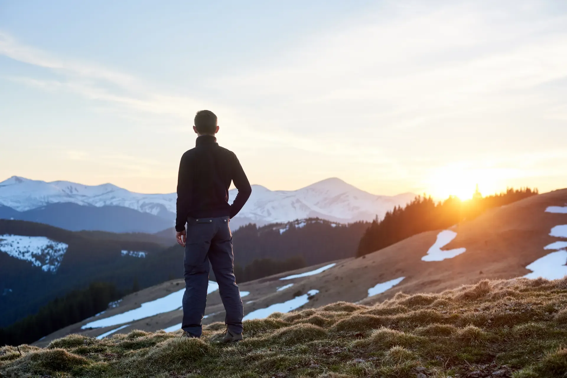 Rear view male hiker watching wonderful scenery mountains spring colorful sunset