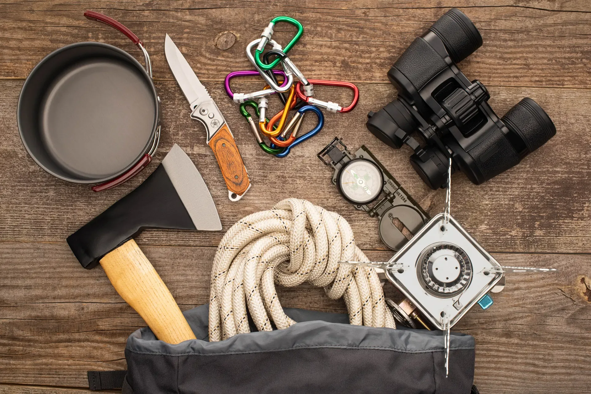 Top view hiking rope axe binoculars knife carabiners compass iron mug gas burner